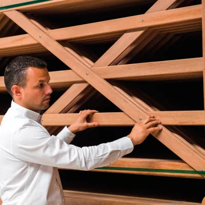 Un homme avec un stock de barrières en bois