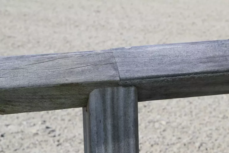 La traverse supérieure continue d'une clôture pour chevaux en bois