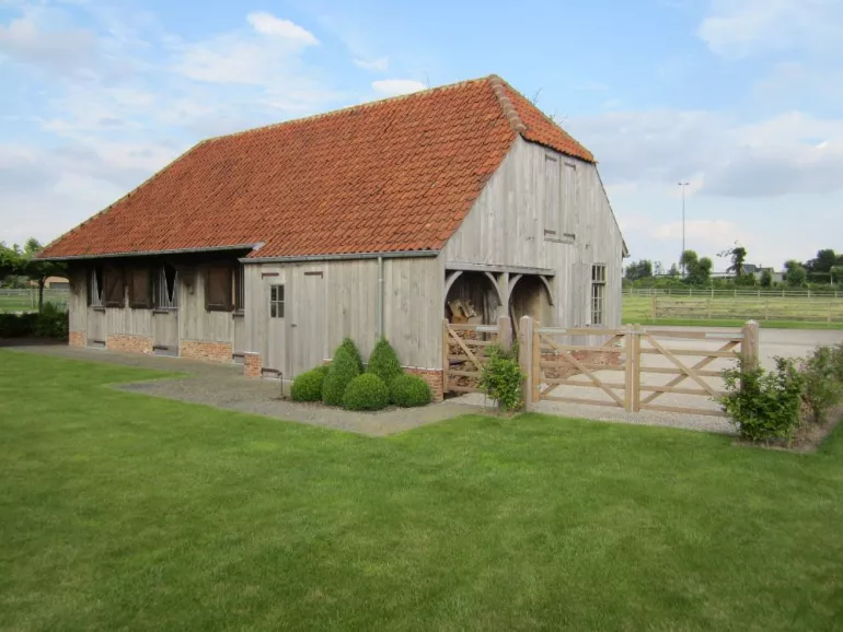 Ein doppeltes Holztor als Eingang zu einem Pferdestall