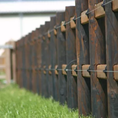 Wooden fences with round posts, 2 rails and electric wires
