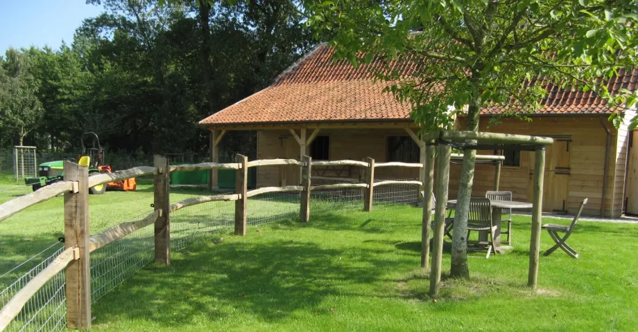 A cleft chestnut fence with 2 rails, square posts and a wire mesh fence at the bottom