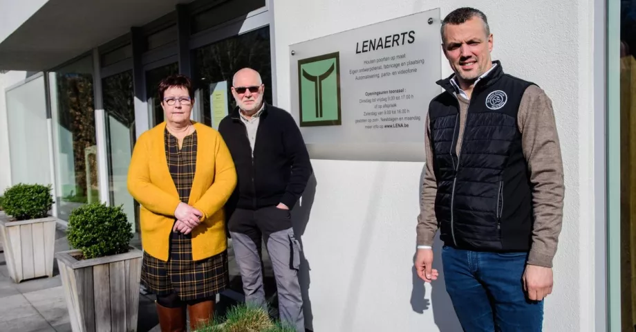3 people in front of a white building